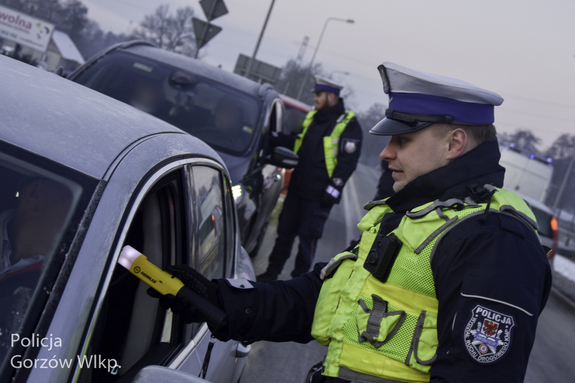 policjanci podchodzą do samochodów i przez uchylonż szybę badają trzeźwość kierowcow